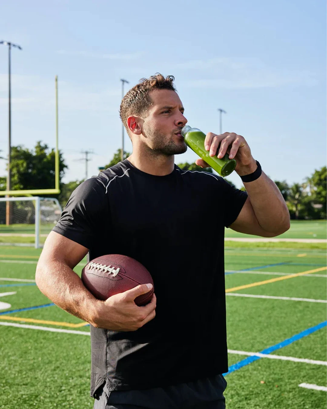 Nick Bosa holding a football and drinking green juice in Hurom’s ambassador photography
