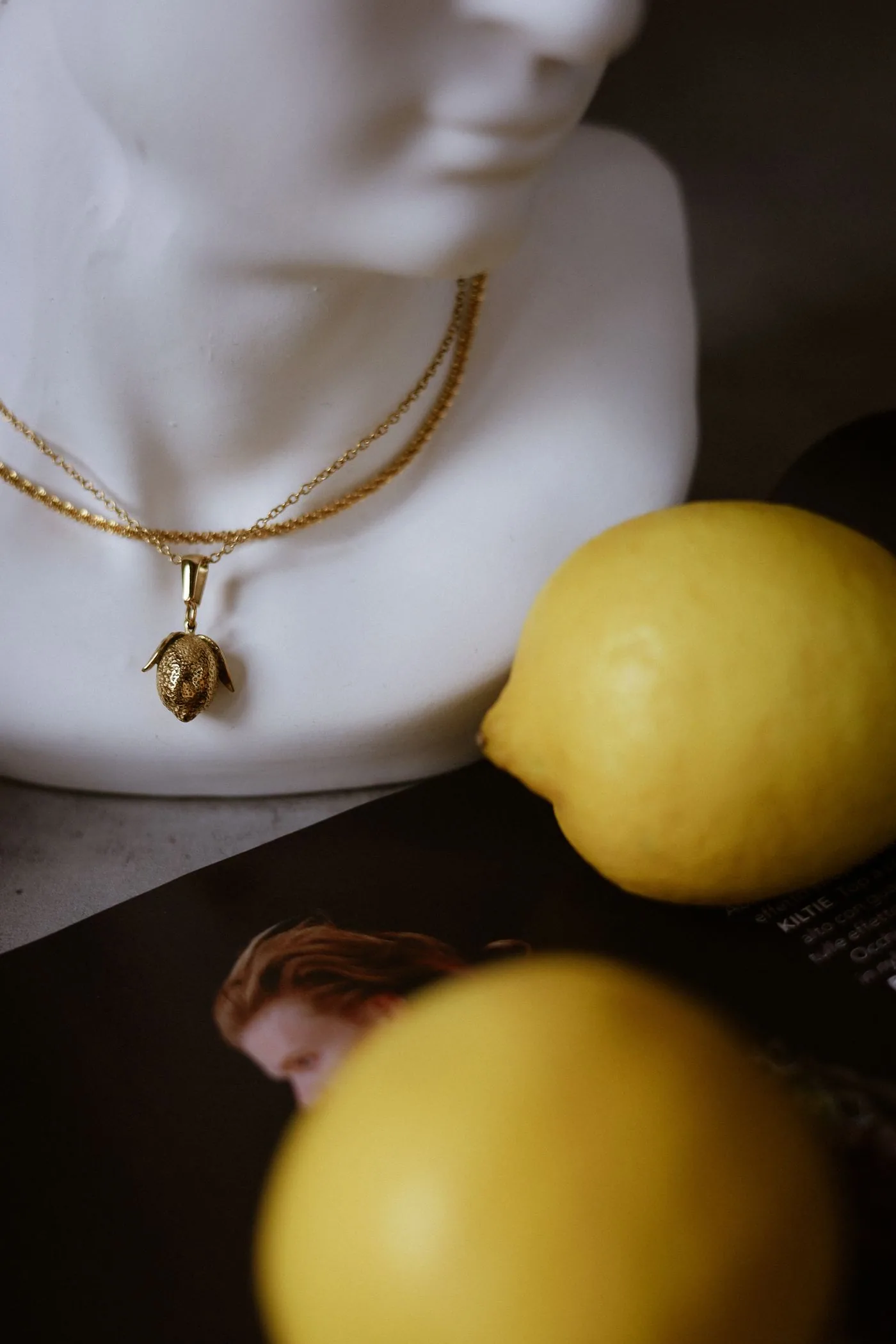 Gold jewelry arranged with lemons